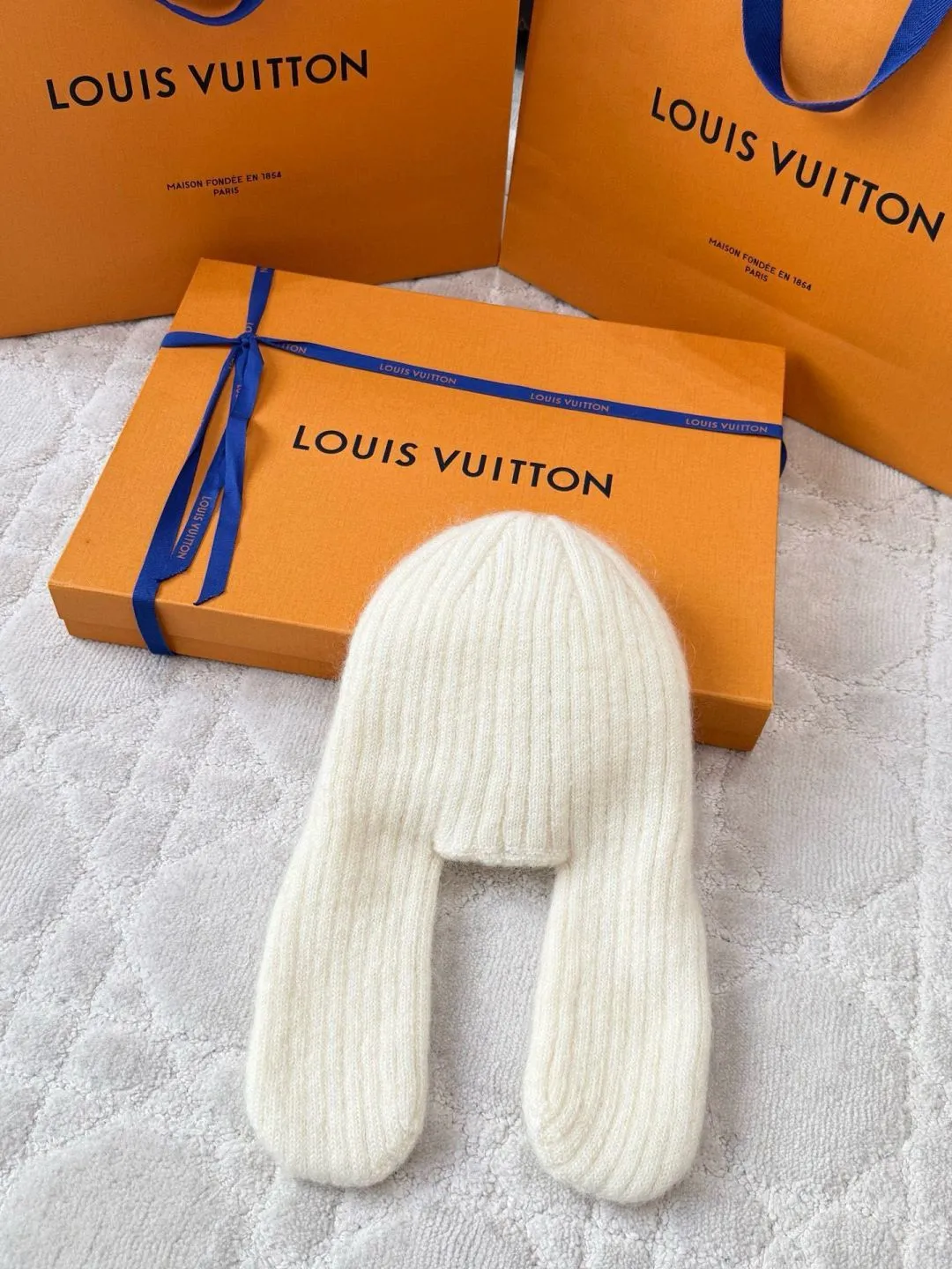 LOUIS VUITTON Autumn and Winter Ski Series Lei Feng Hat ●Original version: 5100 purchase and development ●Item number: 1681971-B05 ●Fabric: wool blended fabric ●Technology: knitted ●Color: white/black/Iceland blue/ ●Version: suitable fit ●Description: Woven by 32-needle fine knitting technology, the suede surface is fluffy and smooth, and its warmth retention is better than ordinary wool hats. The main body of the hat has a vertical grooved stripe texture, which is elastically fit through the fixed-needle shrinking technique. It is suitable for most headbands. The front logo of the hat is made of three-dimensional satin embroidery. The embroidery thread is made of high-gloss yarn of the same color. The stitch density reaches 80 stitches/square centimeter. The pattern is full and not easy to pilling. The ear protection part is woven in one piece, without splicing gaps, making it more comfortable to wear. The finished product is shaped by low-temperature steam to ensure that the hat shape is stiff and not easily deformed. The post-finishing process includes anti-pilling treatment, taking into account both texture and durability. The overall wiring is straight and delicate, the fabric is comfortable and soft, and the color is consistent without color difference. It can be matched with the same style to create a fashionable look and control various occasions. Customized accessories, complete with three standards, same style for men and women!